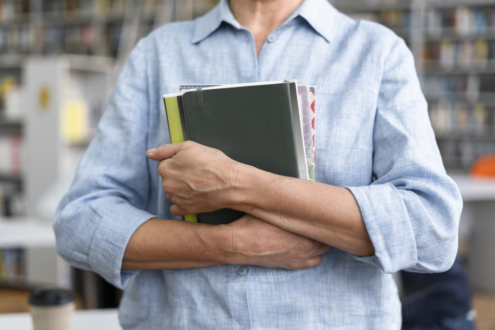 6a196467da0f5_close-up-hands-holding-books.jpg